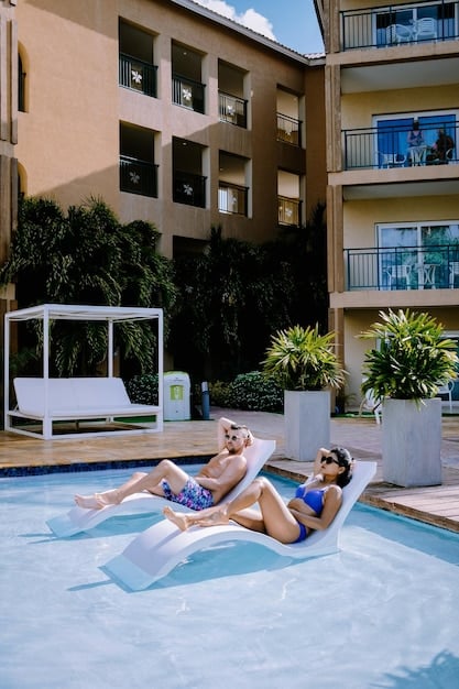 A modern apartment complex with a swimming pool, well-manicured landscaping, and residents enjoying outdoor spaces.