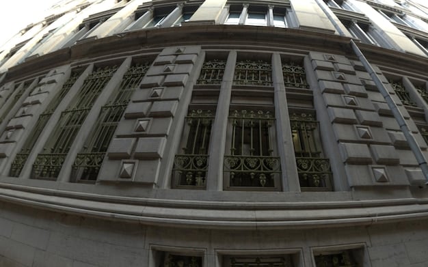 An image depicting the Federal Reserve building with a gavel in the foreground, symbolizing the Fed's regulatory authority and its influence on financial markets, including REITs.