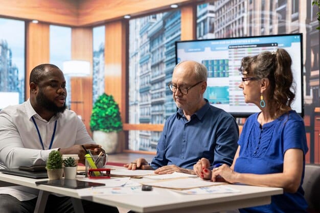A diverse group of individuals discussing real estate investment strategies around a conference table.